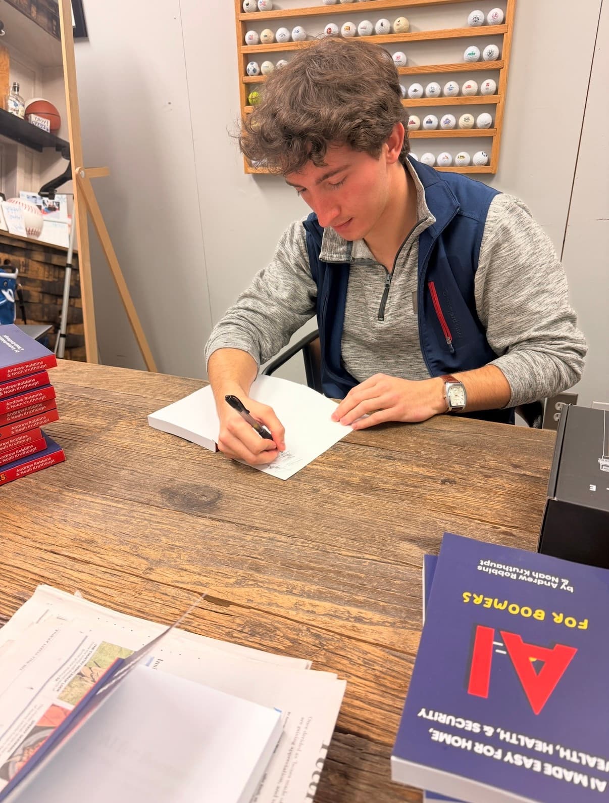 Andy Robbins and Noah Kruthaupt signing copies of AI for Boomers